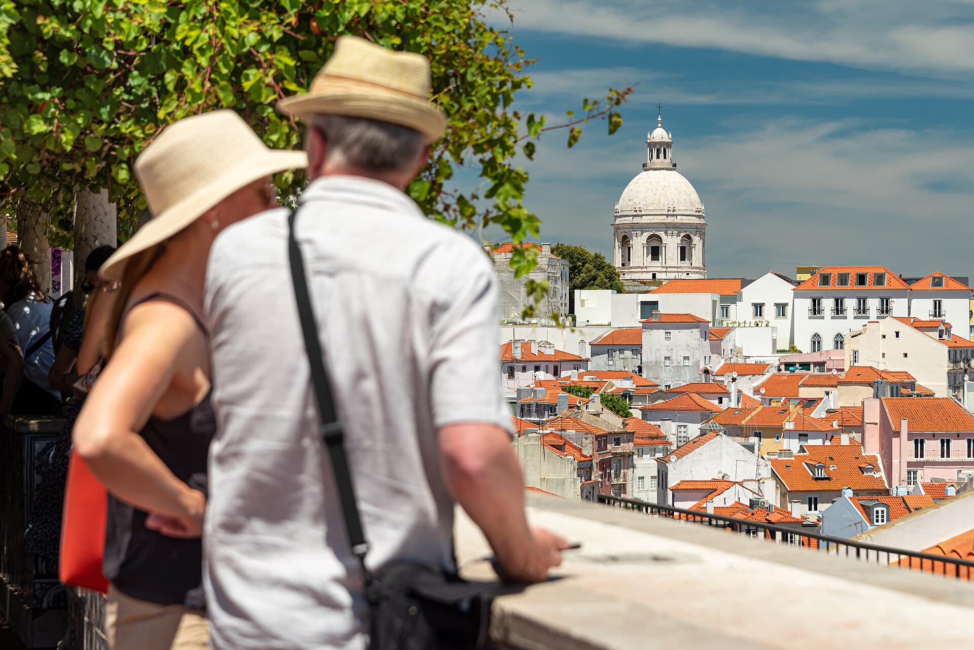 Two visitors looking over the rooftops of Lisbon from a viewpoint